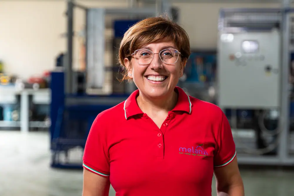 Nuccia Alboni, autrice del libro di ricette dell'azienda, sorride con una polo rossa con il logo Melanzì