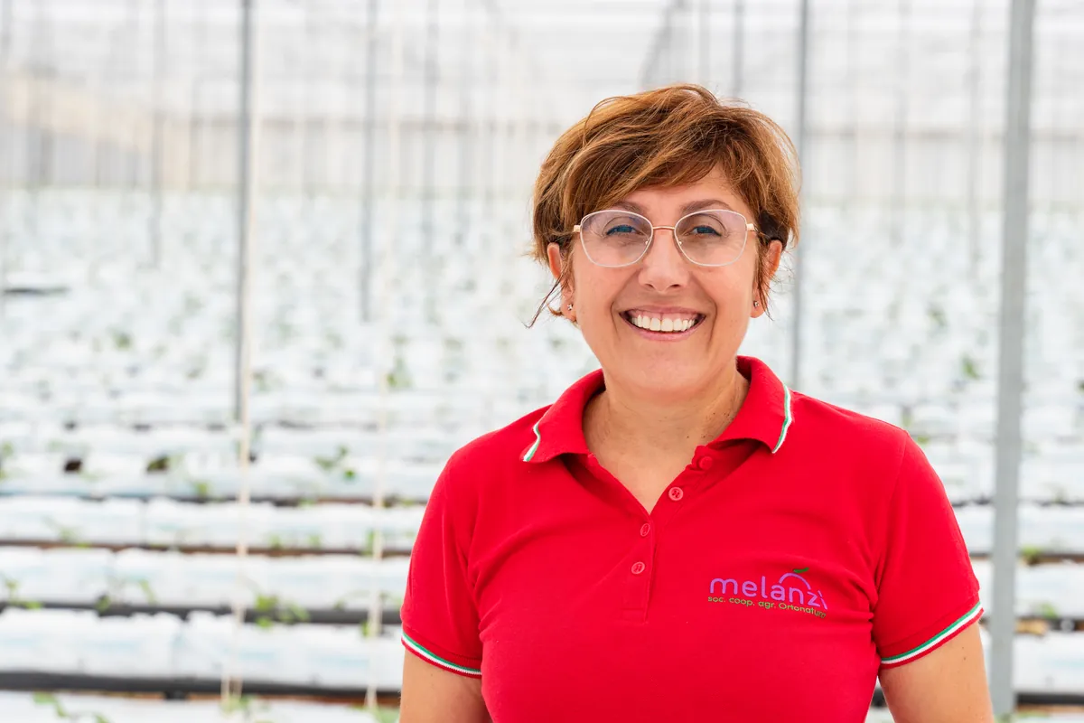 Nuccia Alboni lacht in een kas van Melanzì