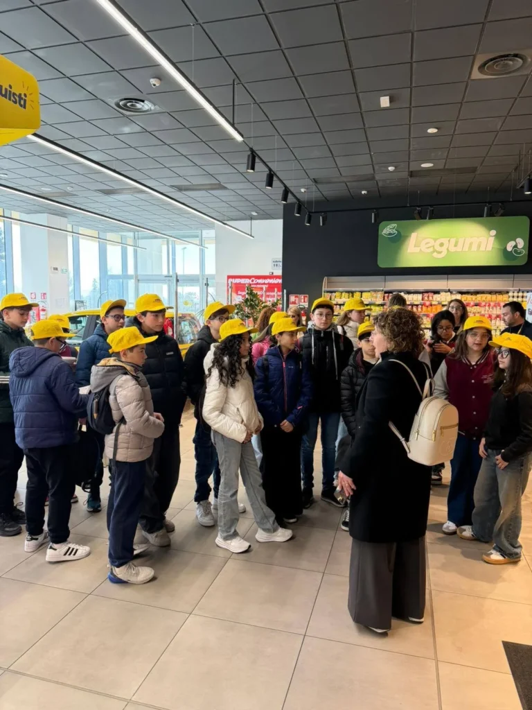 Bambini con il cappellino giallo in gruppo nel supermercato, vicino al reparto dei legumi