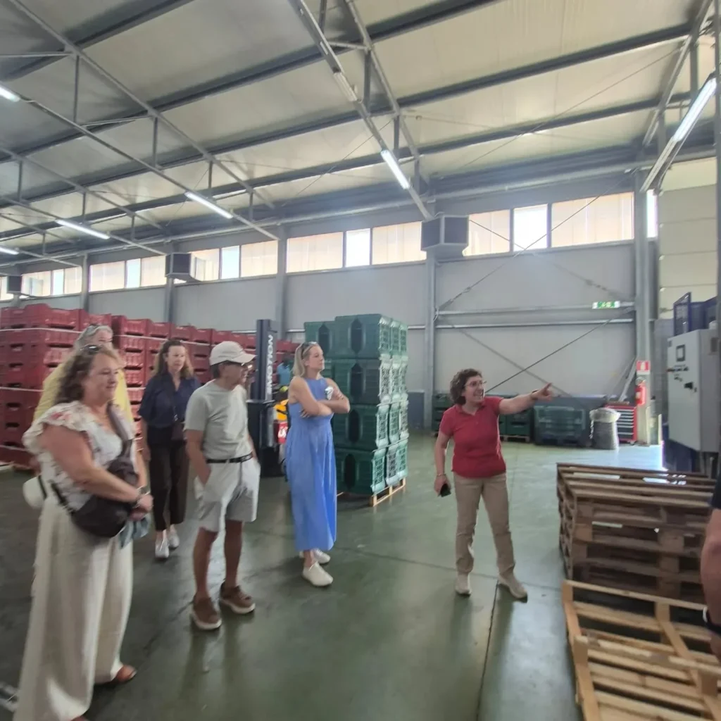 Visitatori nel magazzino mentre ascoltano una spiegazione