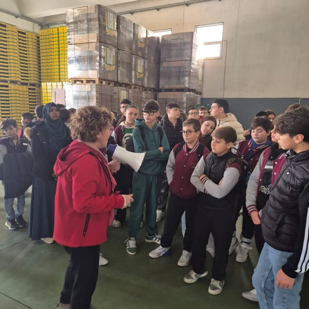 Nuccia Alboni parla con il megafono ai ragazzi di terza media nel magazzino