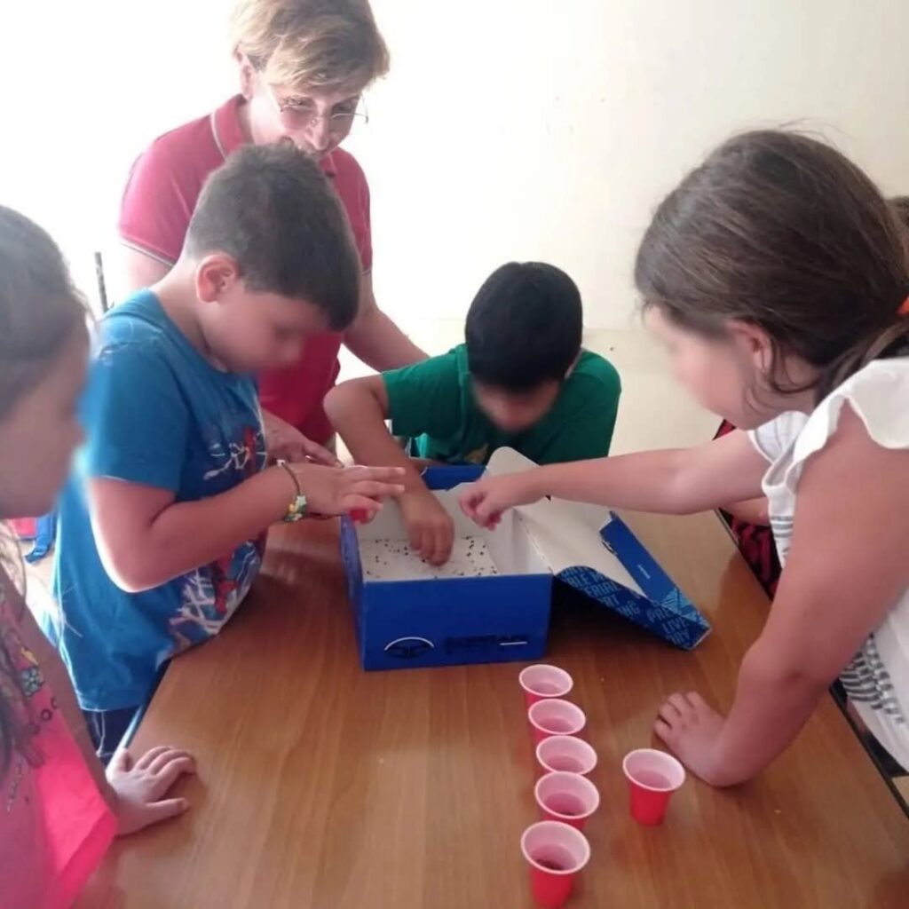 Bambini che dividono i semi nei bicchierini durante il laboratorio